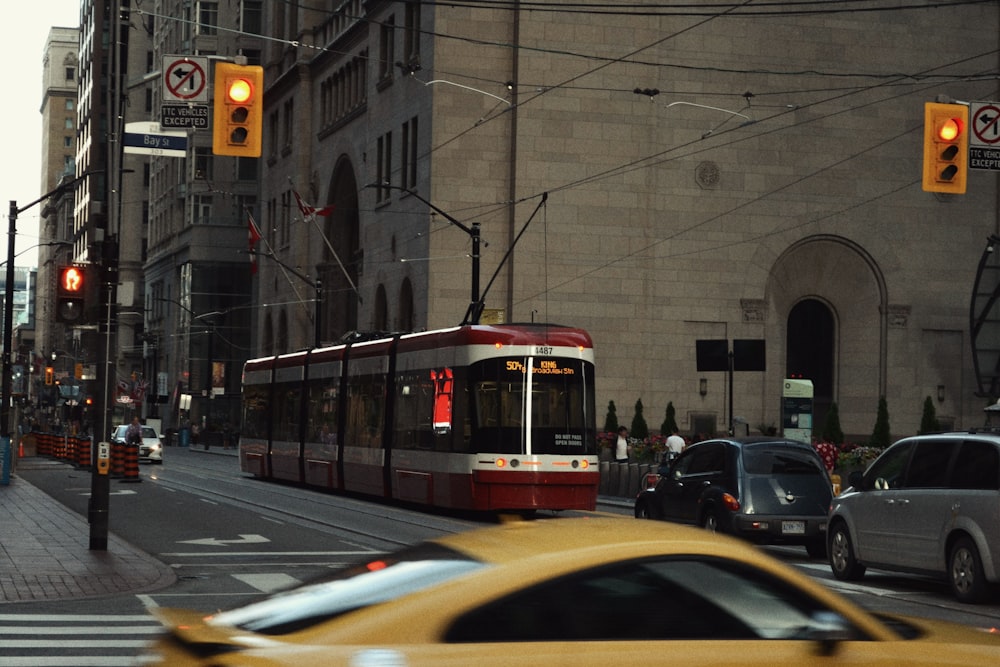 a red and white trolley on a city street