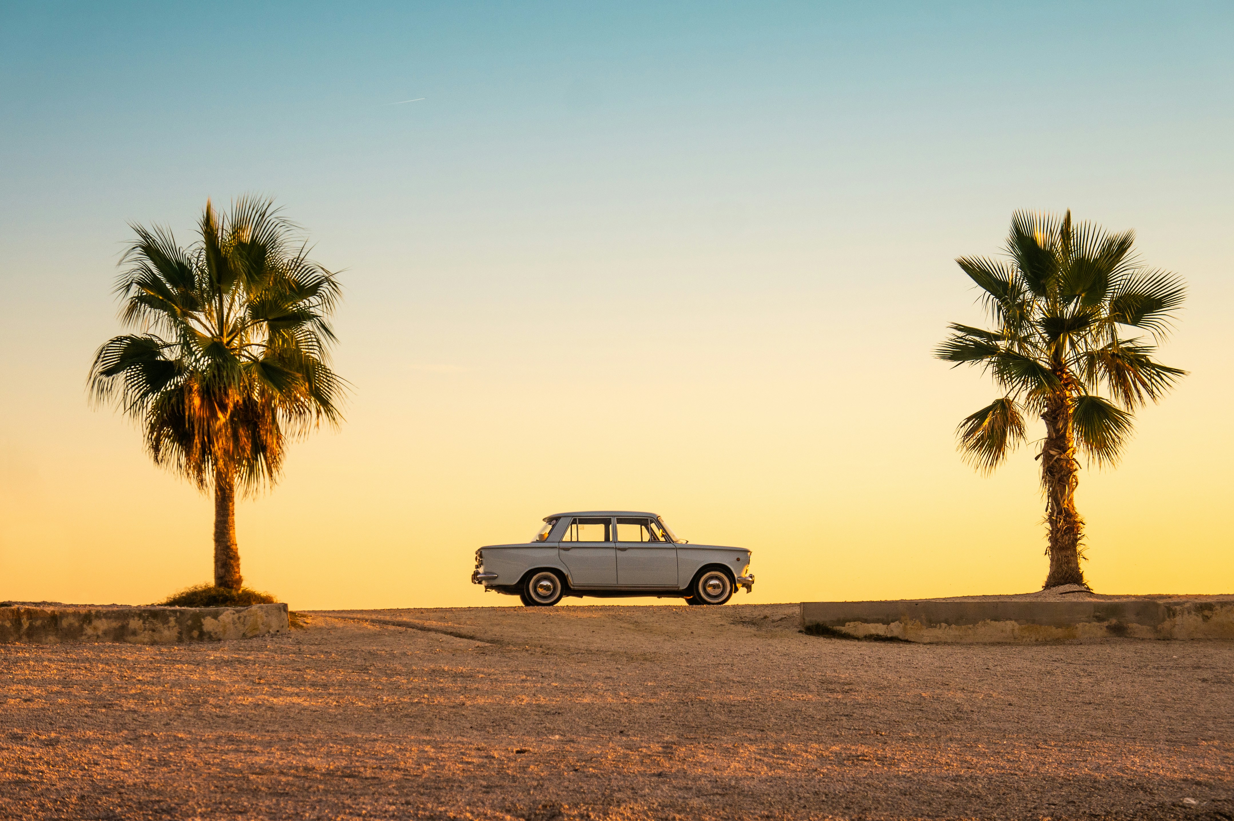 great photo recipe,how to photograph white and black car on brown sand during daytime