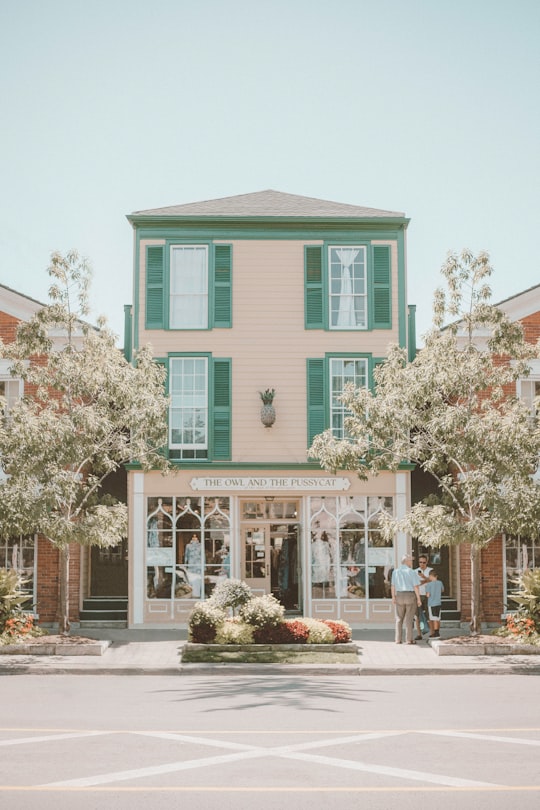 cars parked in front of teal and white concrete building during daytime in Niagara-on-the-Lake Canada