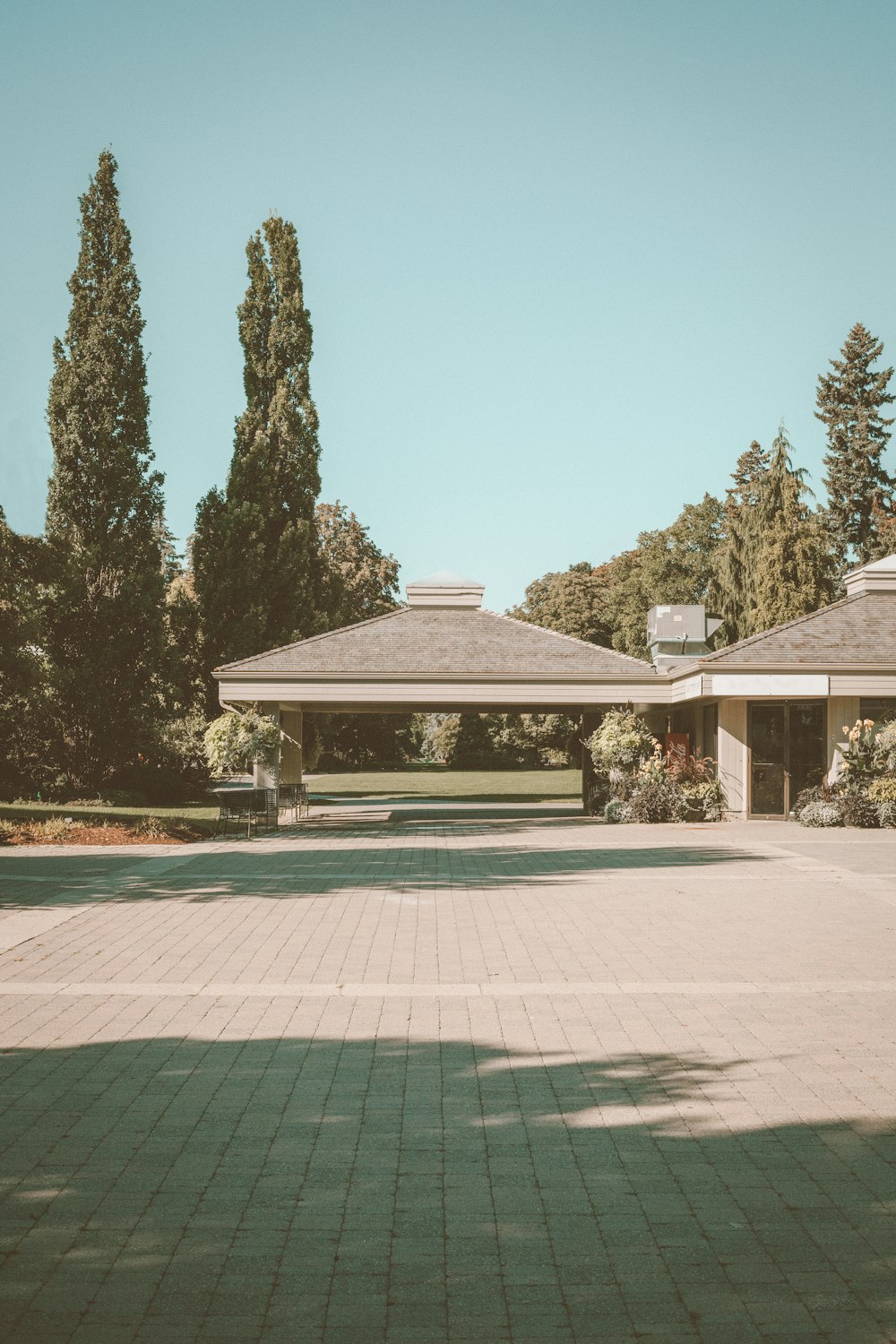 white and brown concrete house near green trees under blue sky during daytime