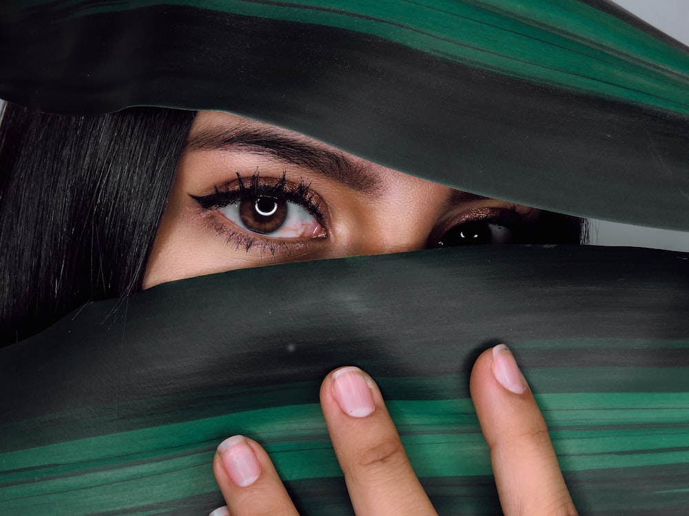 woman covering her face with green textile