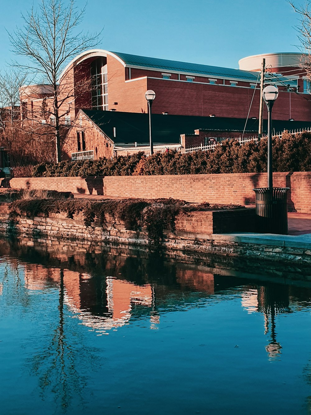 brown brick building near body of water during daytime