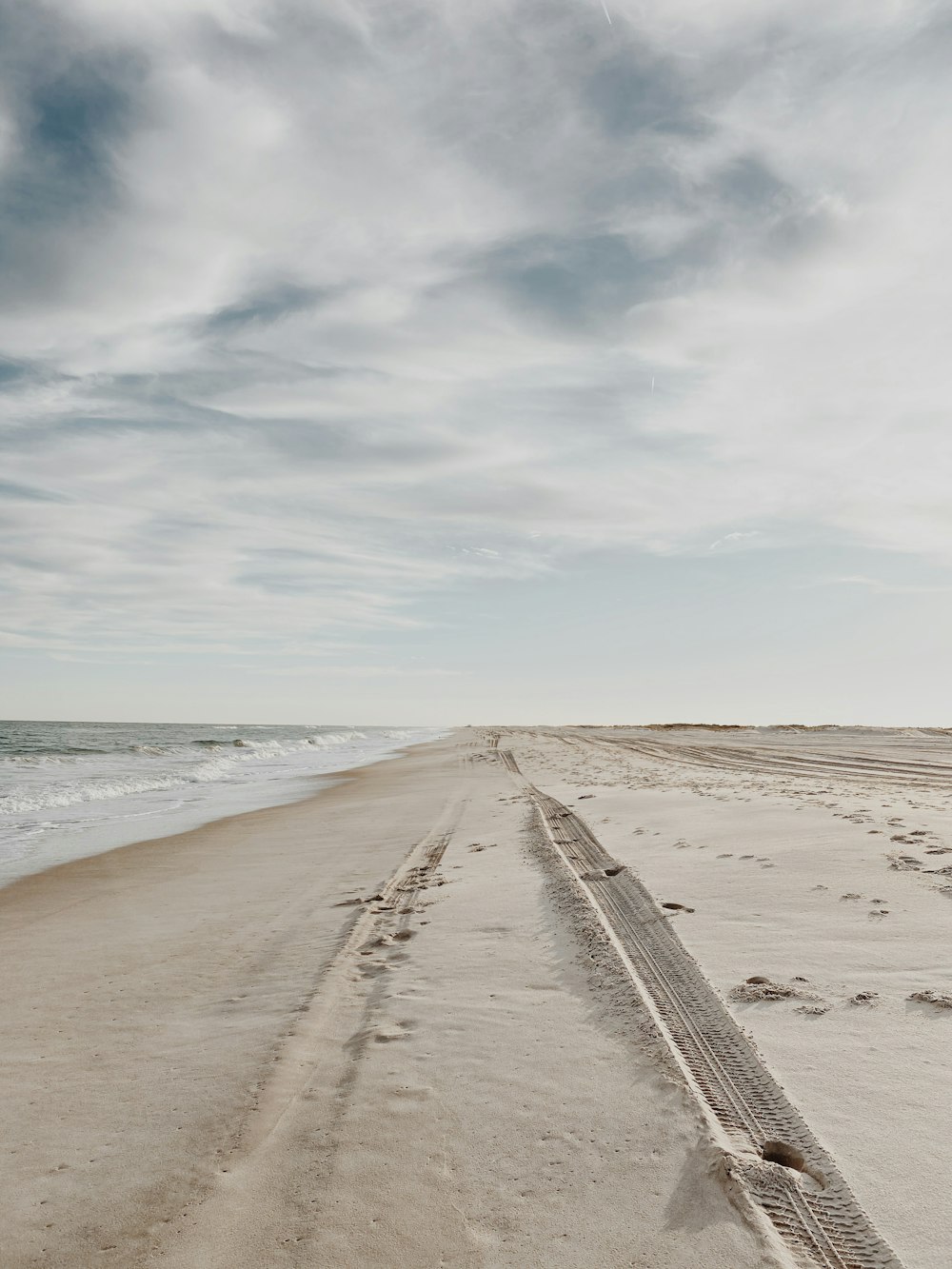 brown sand near sea under white clouds during daytime