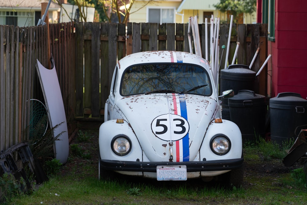 white volkswagen beetle parked on green grass field during daytime