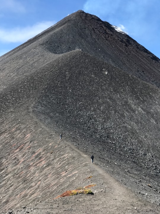 person walking on gray sand during daytime in Volcán de Fuego Guatemala