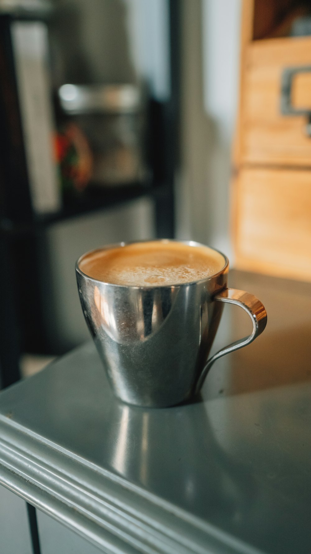 brown liquid in silver and white ceramic mug