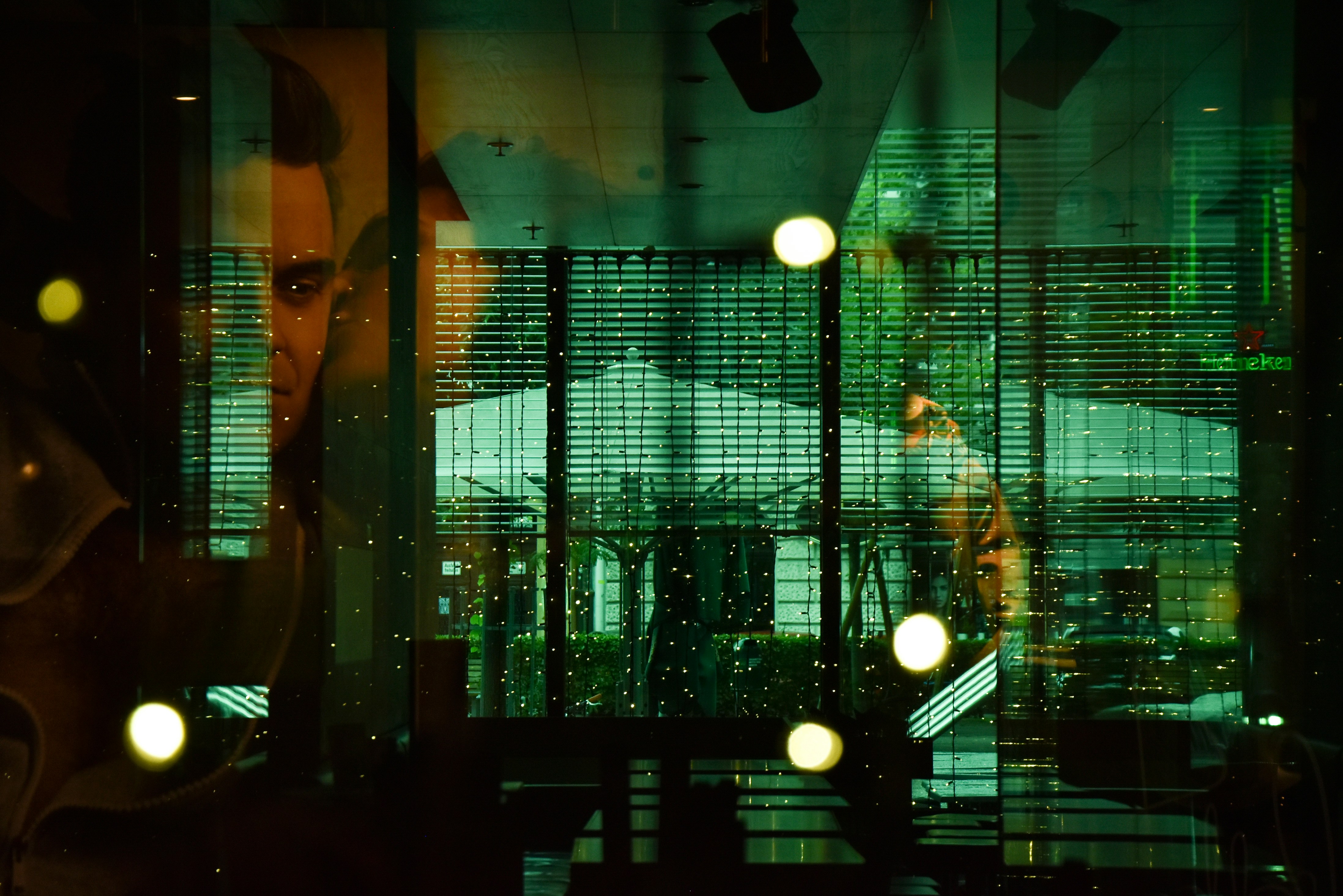 A portrait of Dario Amodei looking determined, contrasted with a blurry background of military technology and surveillance screens