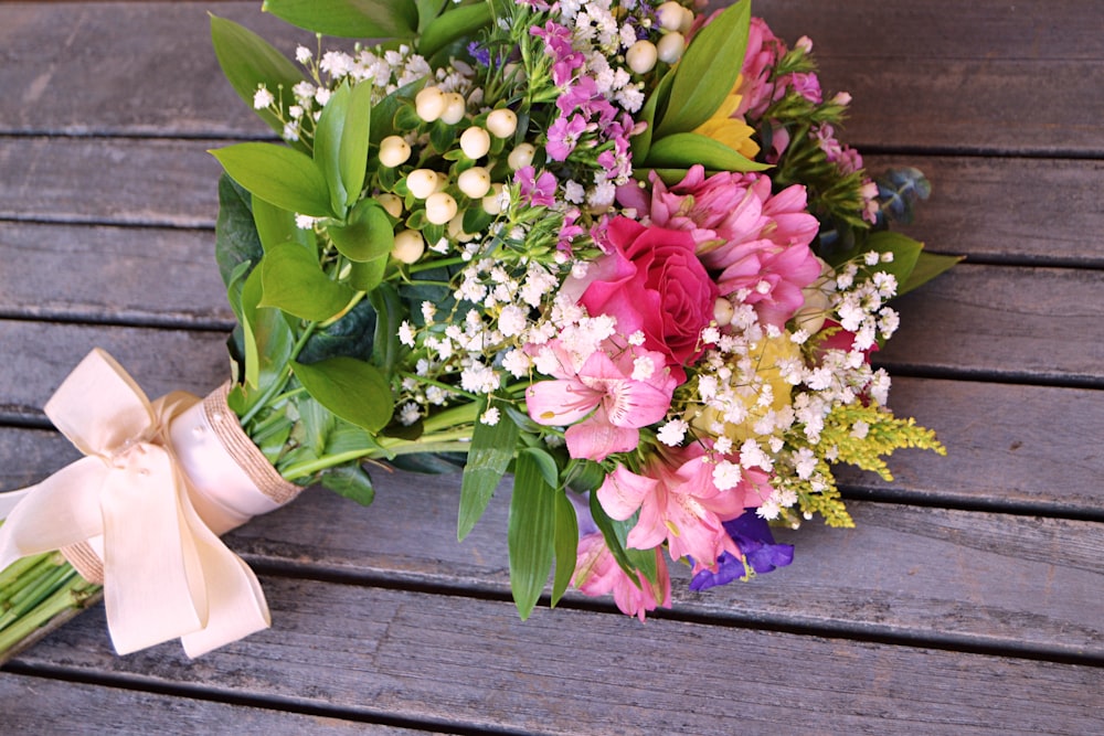 pink and white flowers on brown wooden table