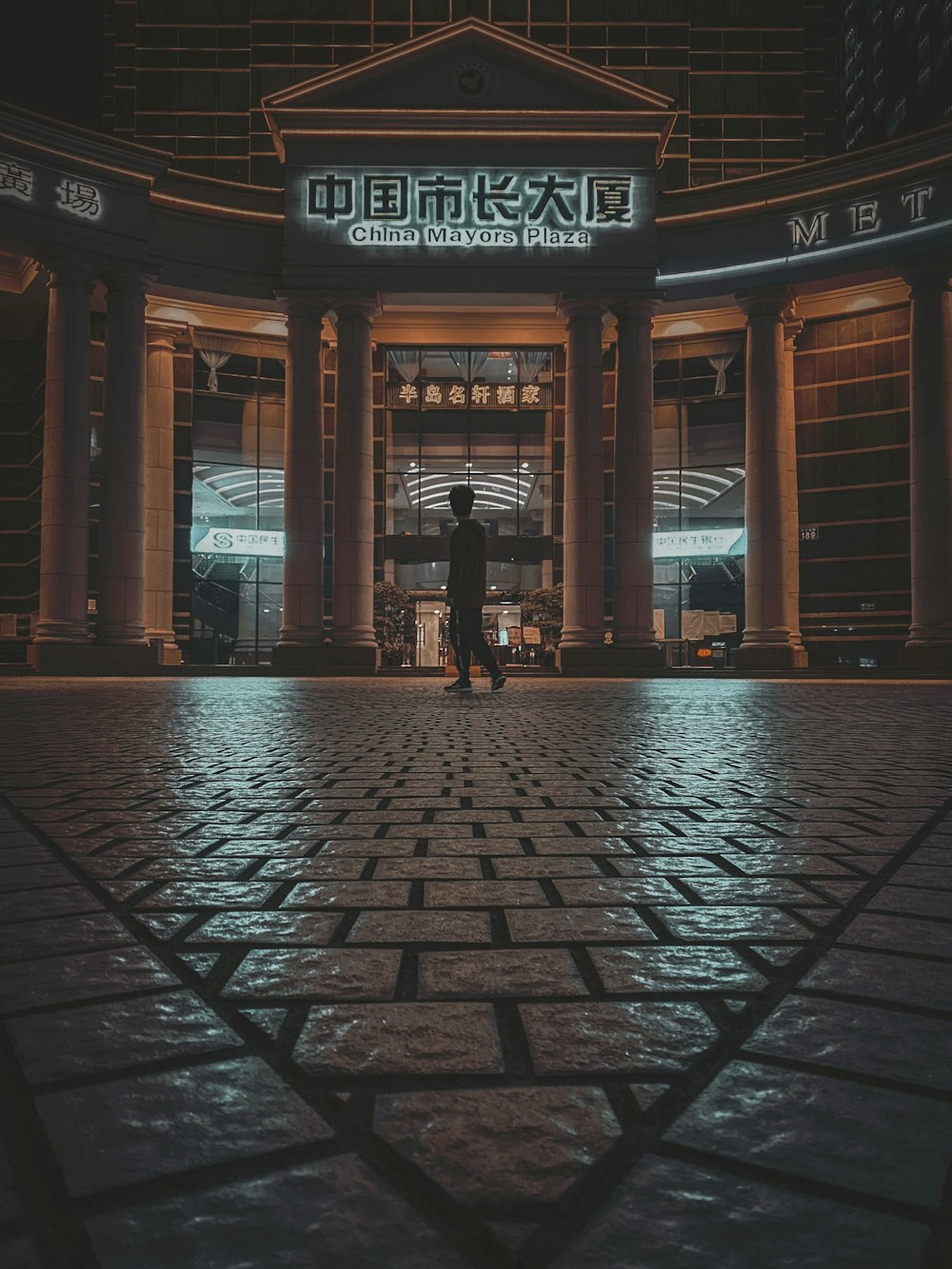 woman in black jacket walking on sidewalk during night time