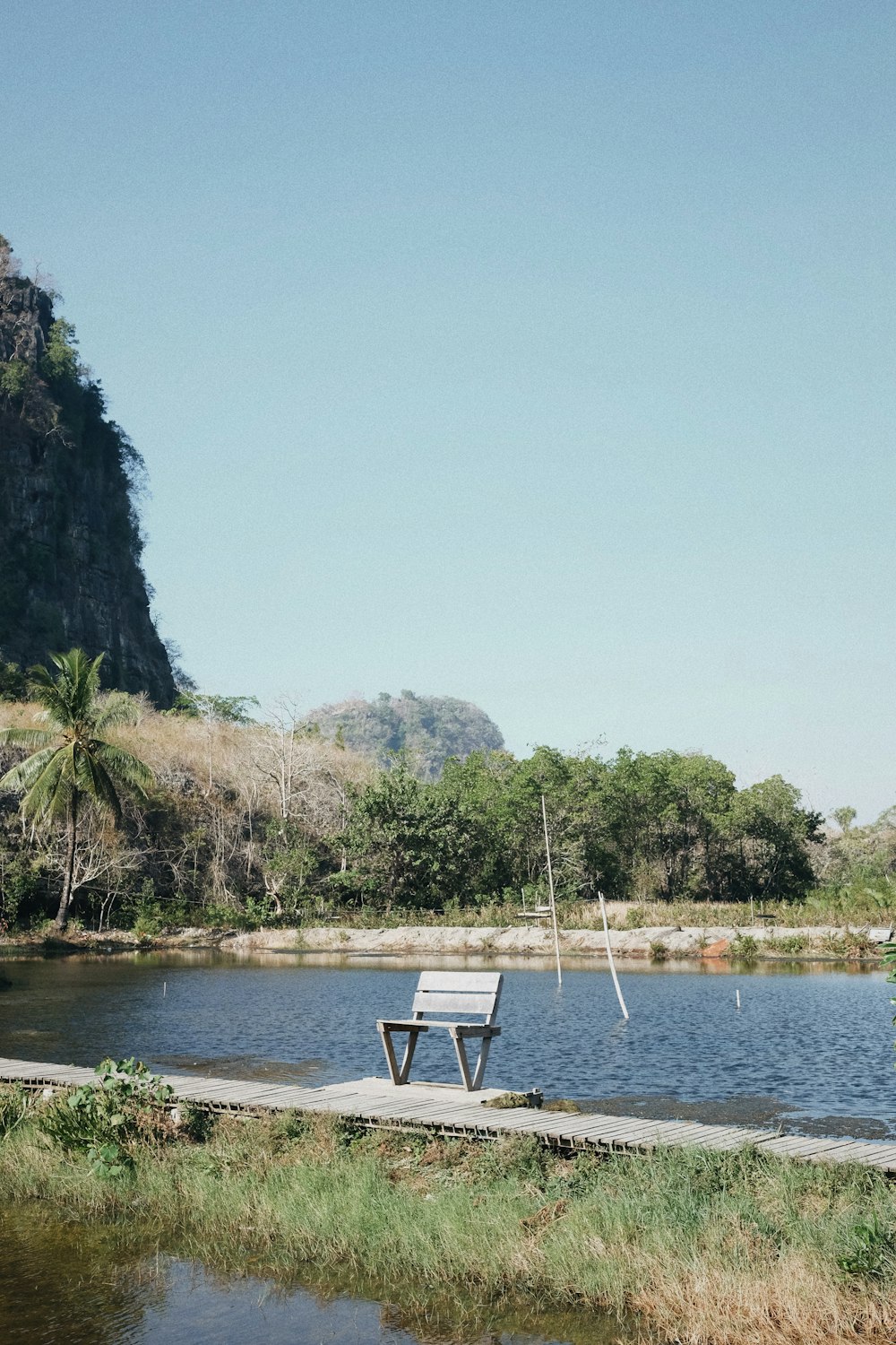 white and black wooden bench near body of water during daytime