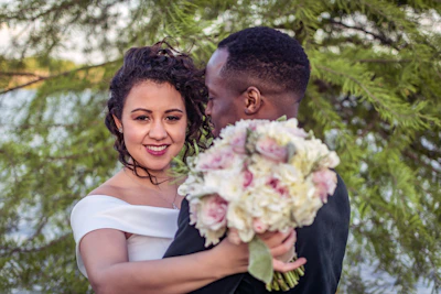 man in black shirt holding white flower bouquet