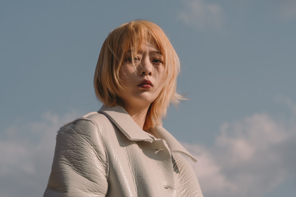 woman in gray coat under blue sky during daytime