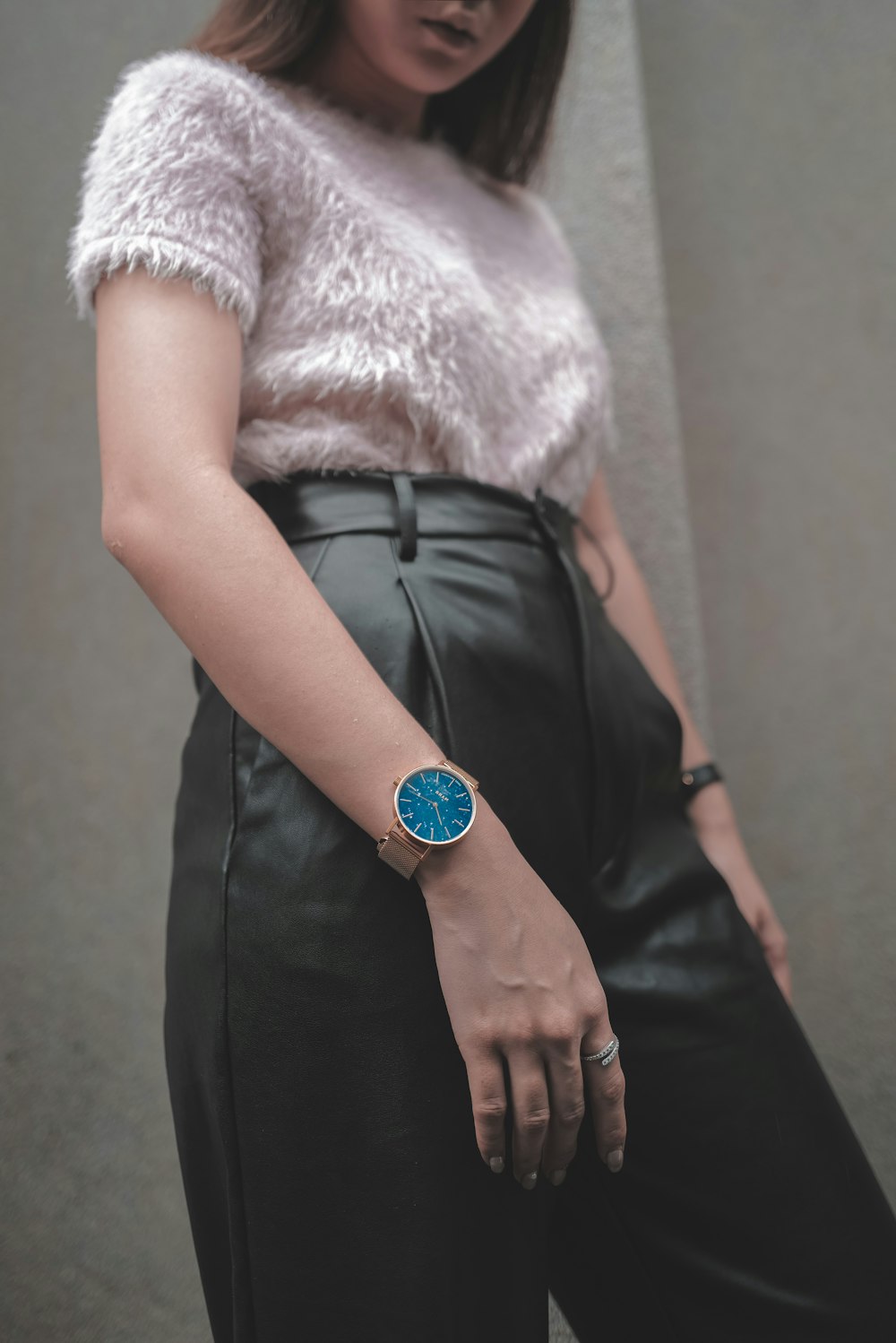 woman in white fur coat wearing blue analog watch