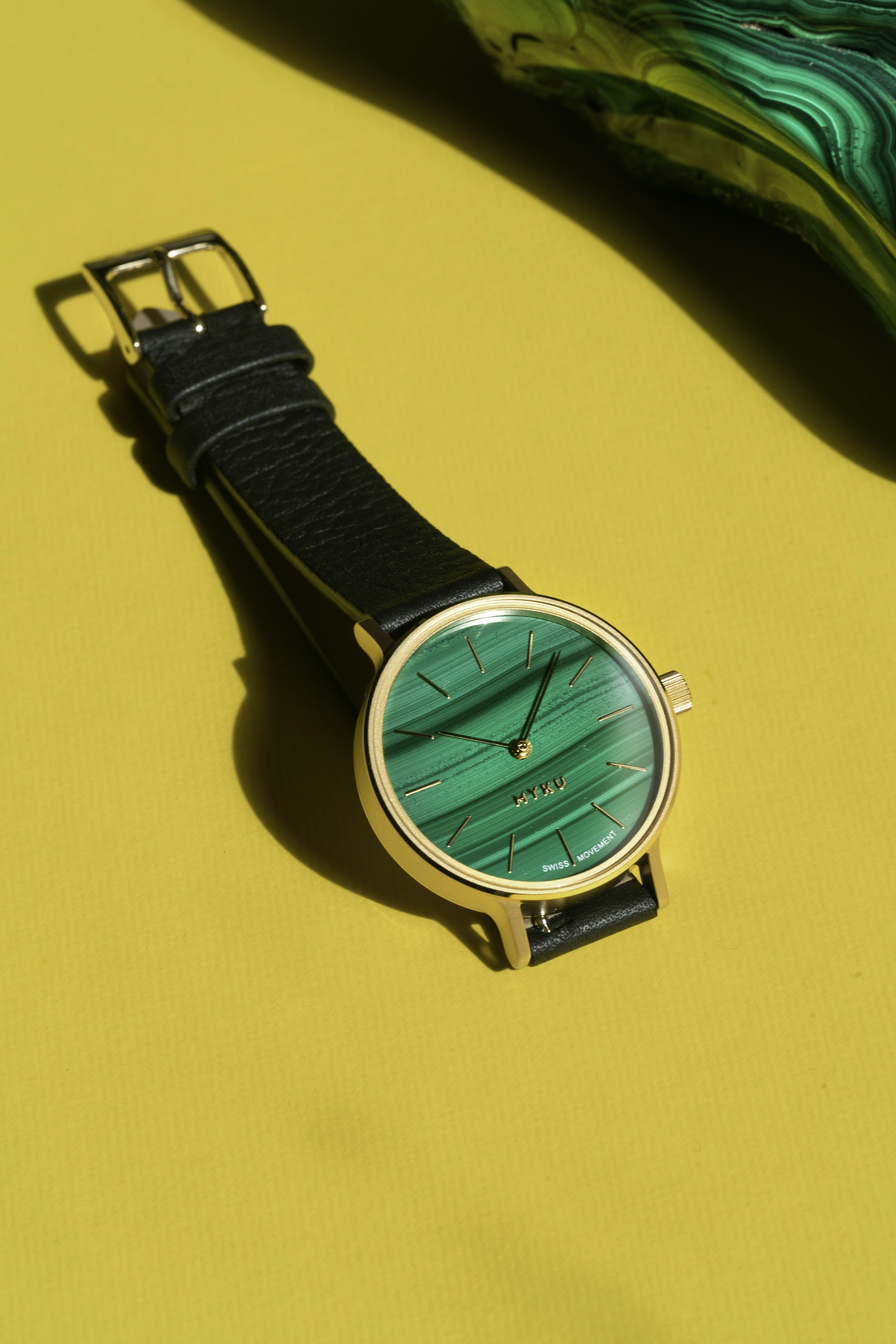 Eine Uhr, die auf einem gelben Tisch sitzt