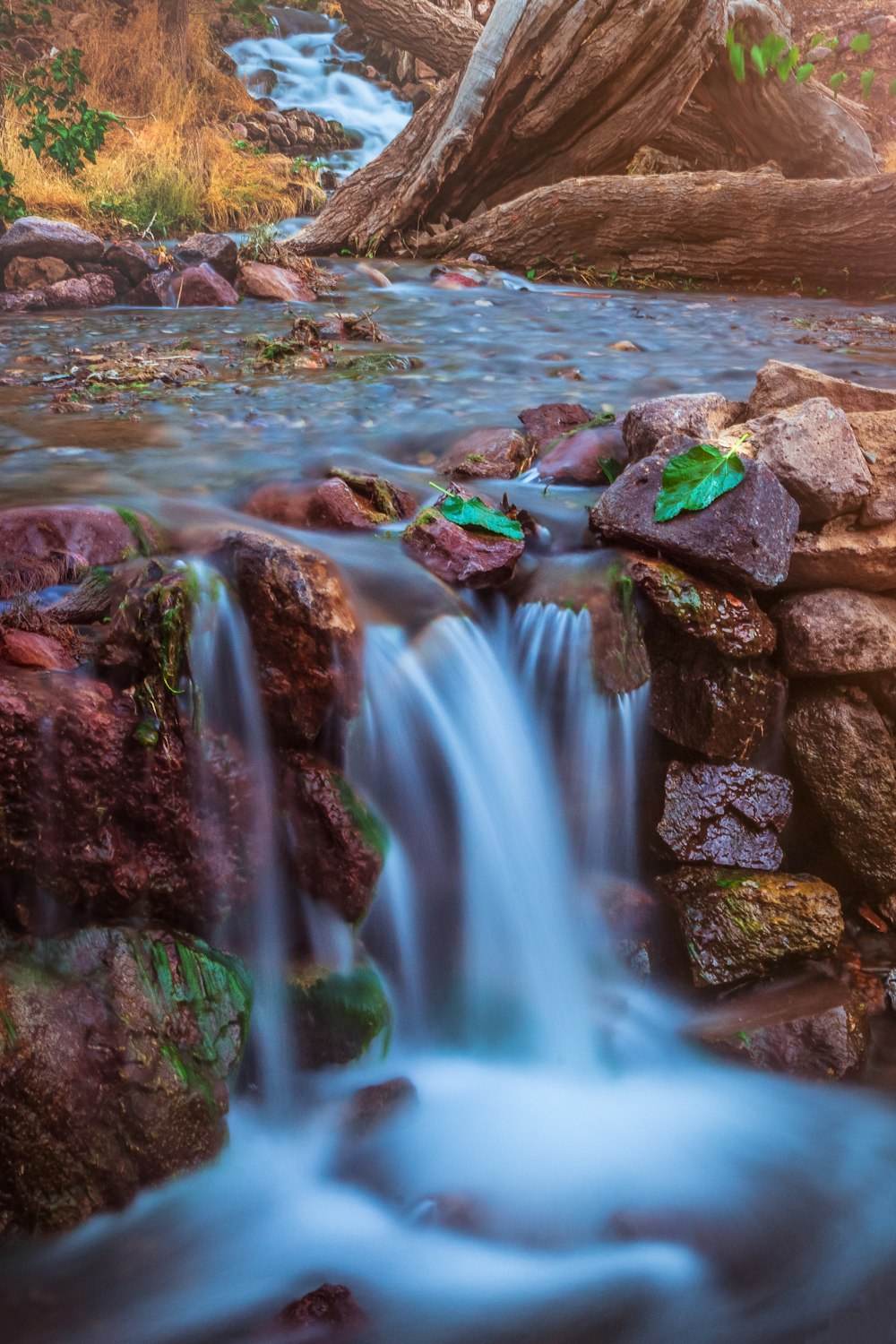 water falls on rocky shore during daytime