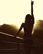 woman standing on balcony during sunset