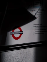 A partially shadowed section of a travel map includes a prominent symbol featuring a red circle with the word 'Underground' in blue. Lines and text details appear around the symbol.