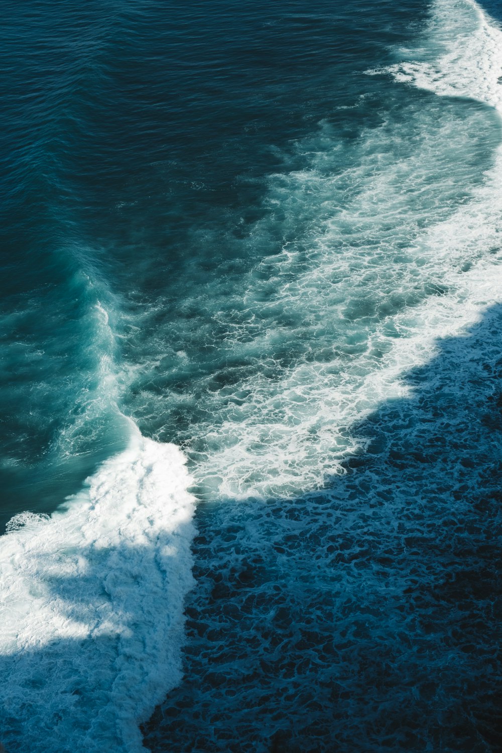 ocean waves crashing on shore during daytime