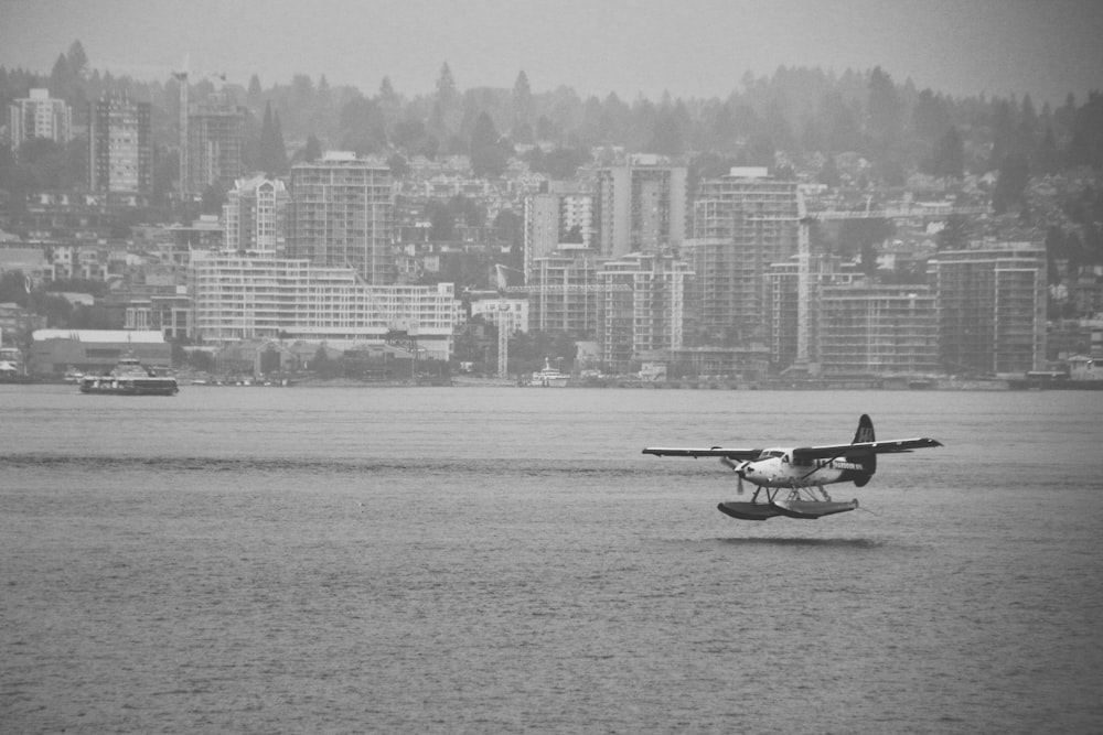 grayscale photo of man riding on boat on body of water