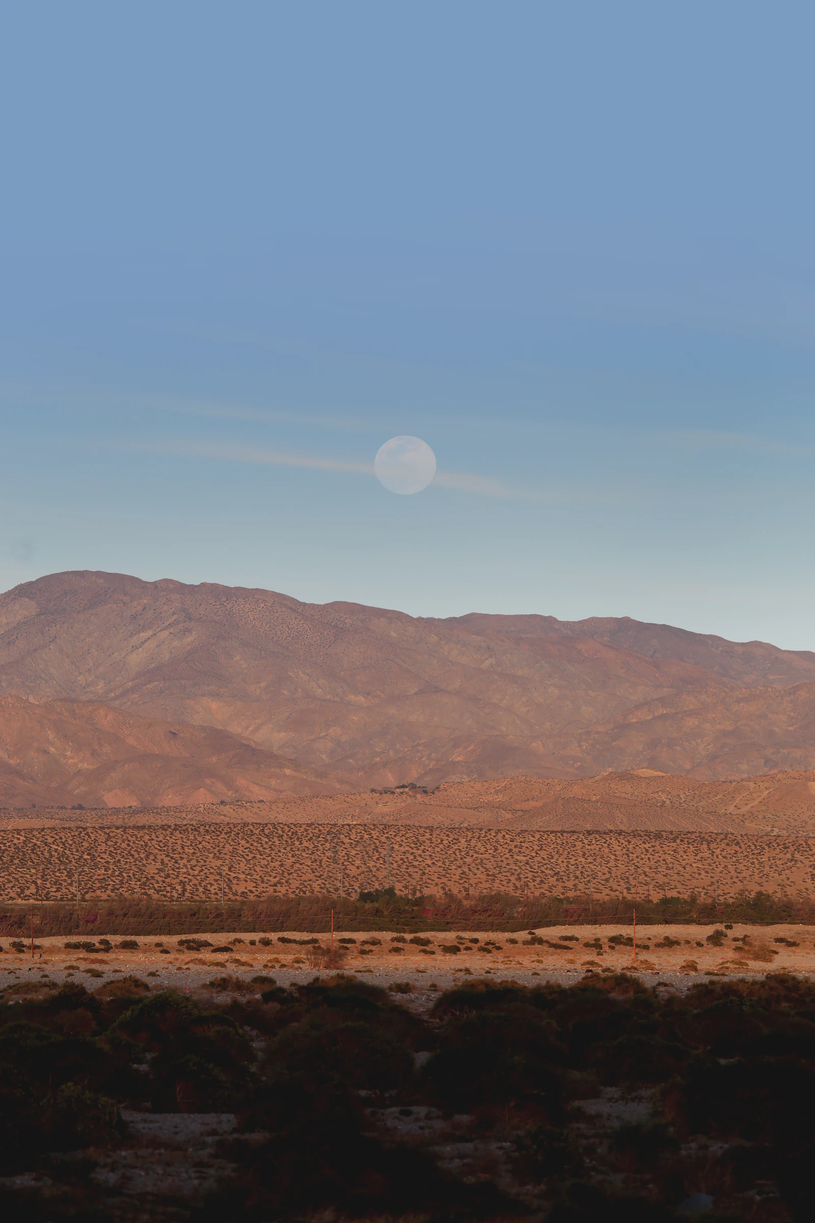 Bare desert mountains under a blue sky