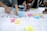 Several individuals are using colorful sticky notes on a table covered with printed papers. The notes have words like 'customer', 'problem', and 'journey map', indicating a collaborative planning or brainstorming session. Hands are visible, actively arranging the notes.