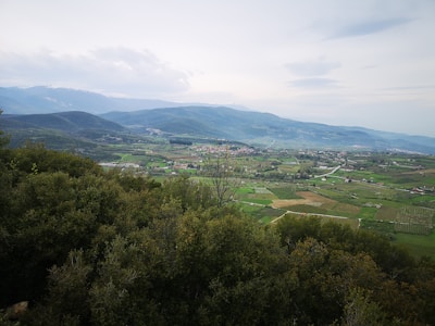 A panoramic view of a peaceful valley embraced by mountains, inviting exploration.