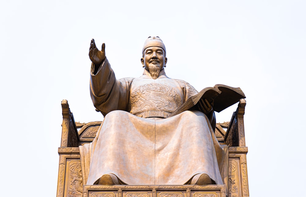 Estatua de hormigón gris bajo el cielo blanco durante el día