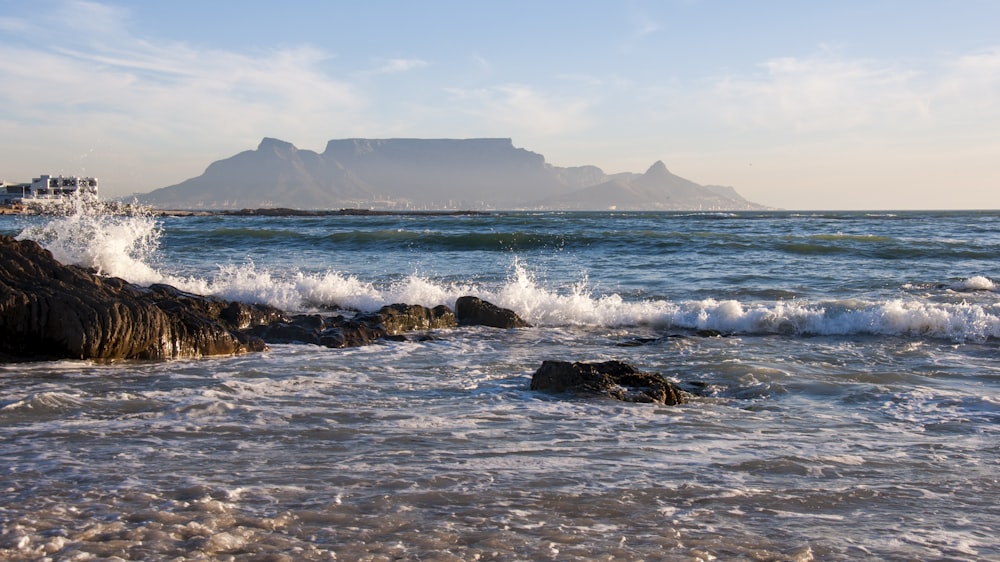 Las olas del mar rompiendo contra las rocas durante el día