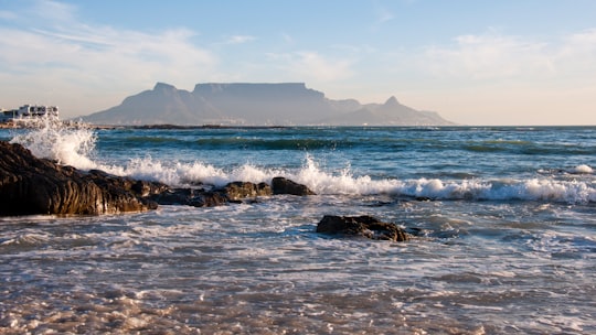 ocean waves crashing on rocks during daytime in Bloubergstrand South Africa