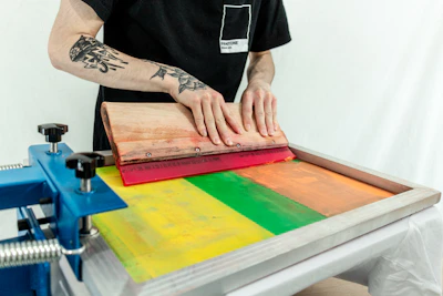 man in black t-shirt standing beside brown wooden table