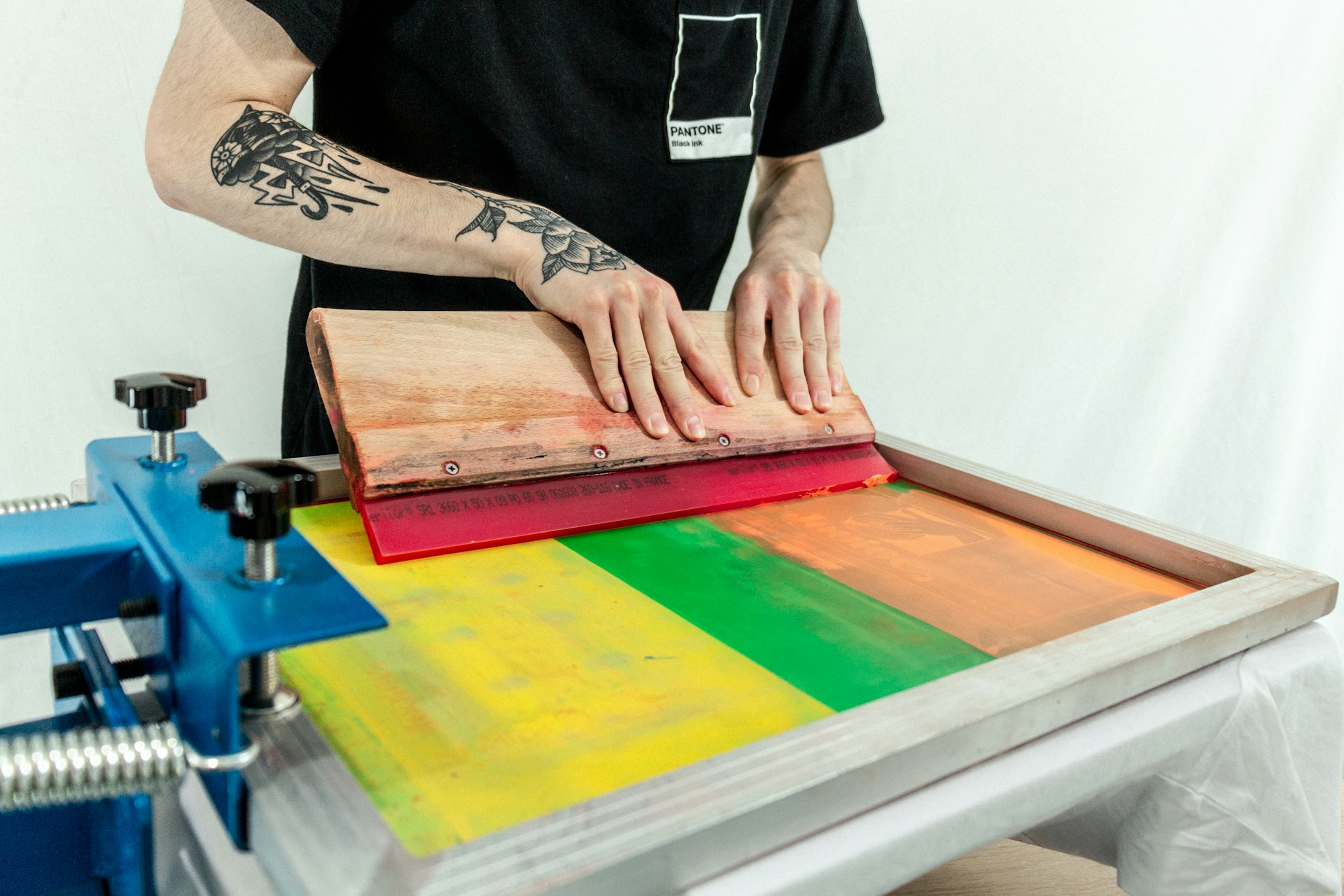 man in black t-shirt standing beside brown wooden table