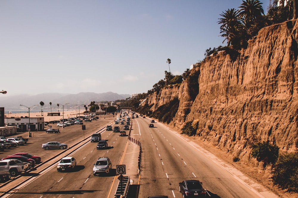 cars on road near mountain during daytime