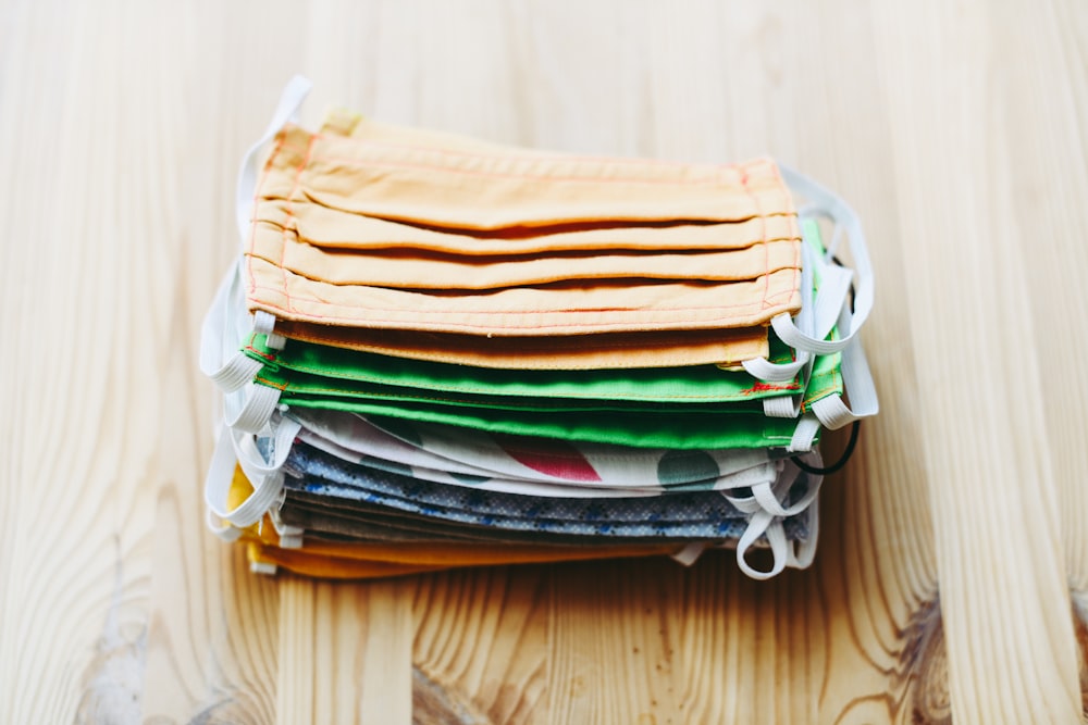 stack of white yellow green and blue textiles