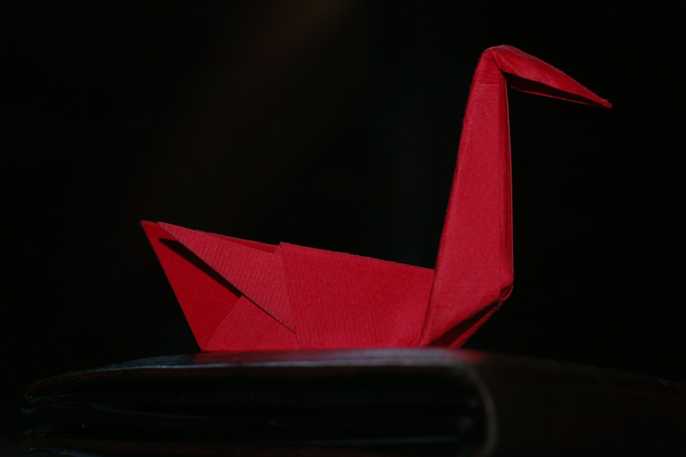 red paper plane on black surface