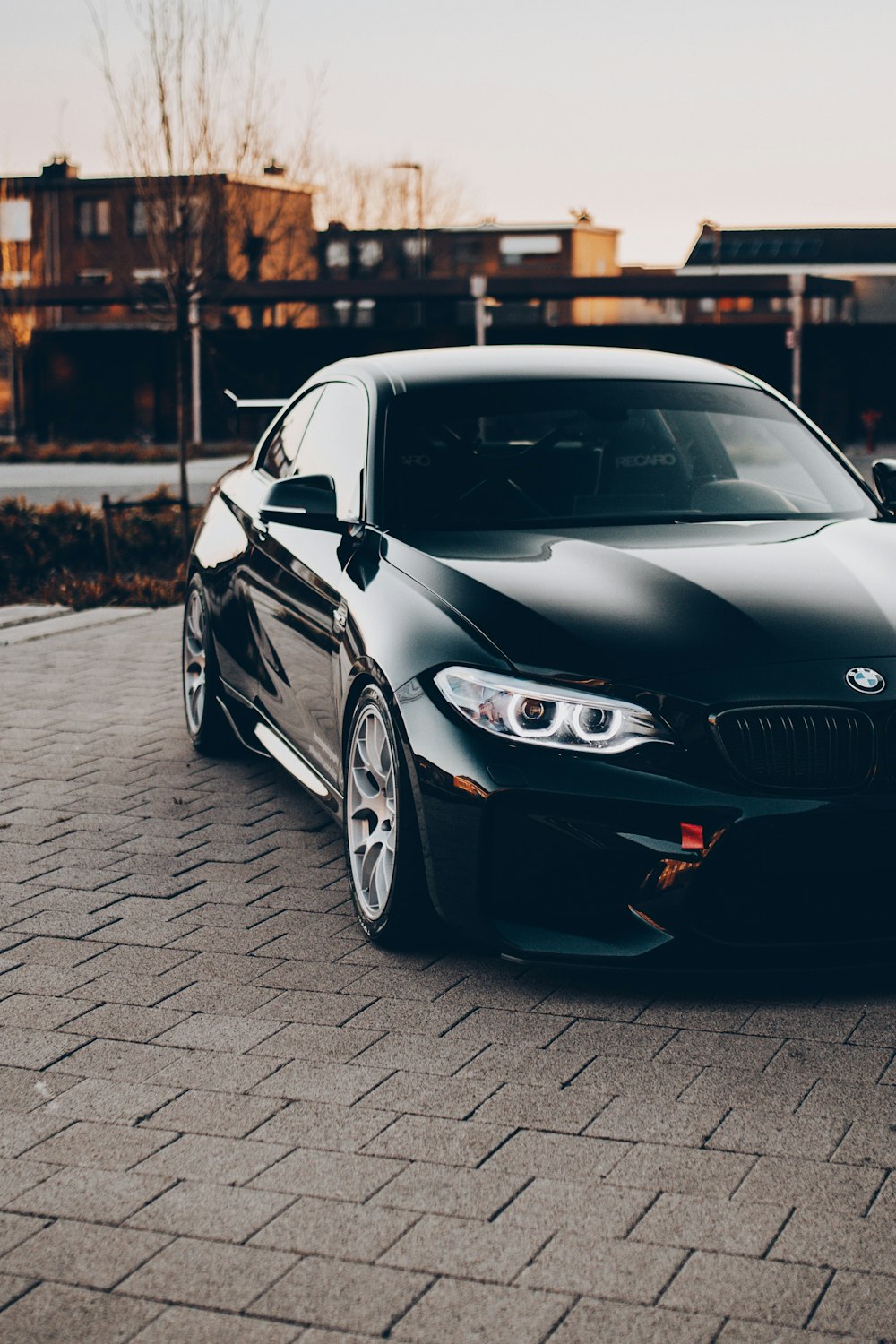 black bmw m 3 coupe parked on gray brick pavement during daytime