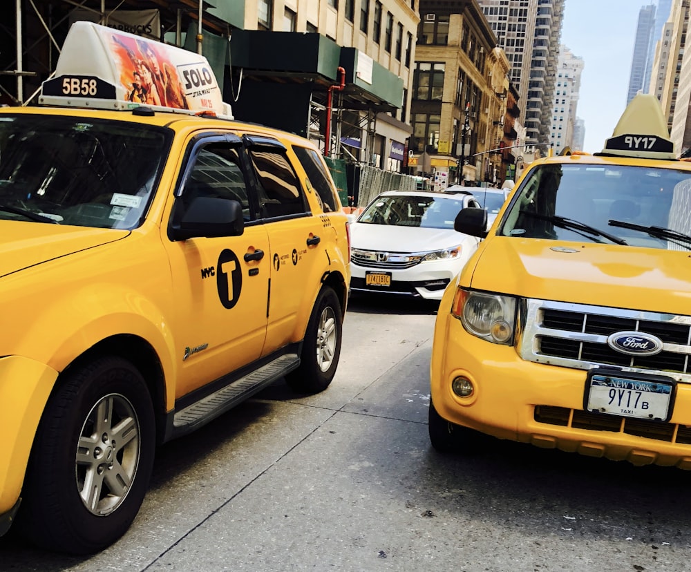 yellow taxi cab on the street during daytime