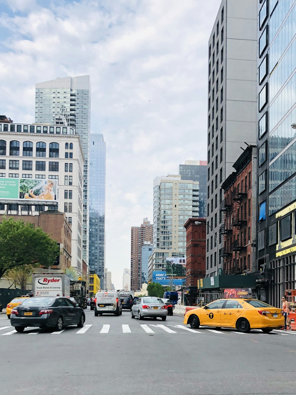 a city street filled with traffic next to tall buildings