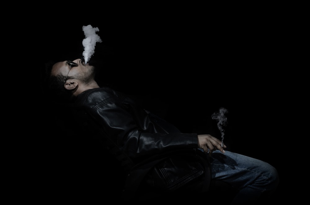 man in black leather jacket smoking