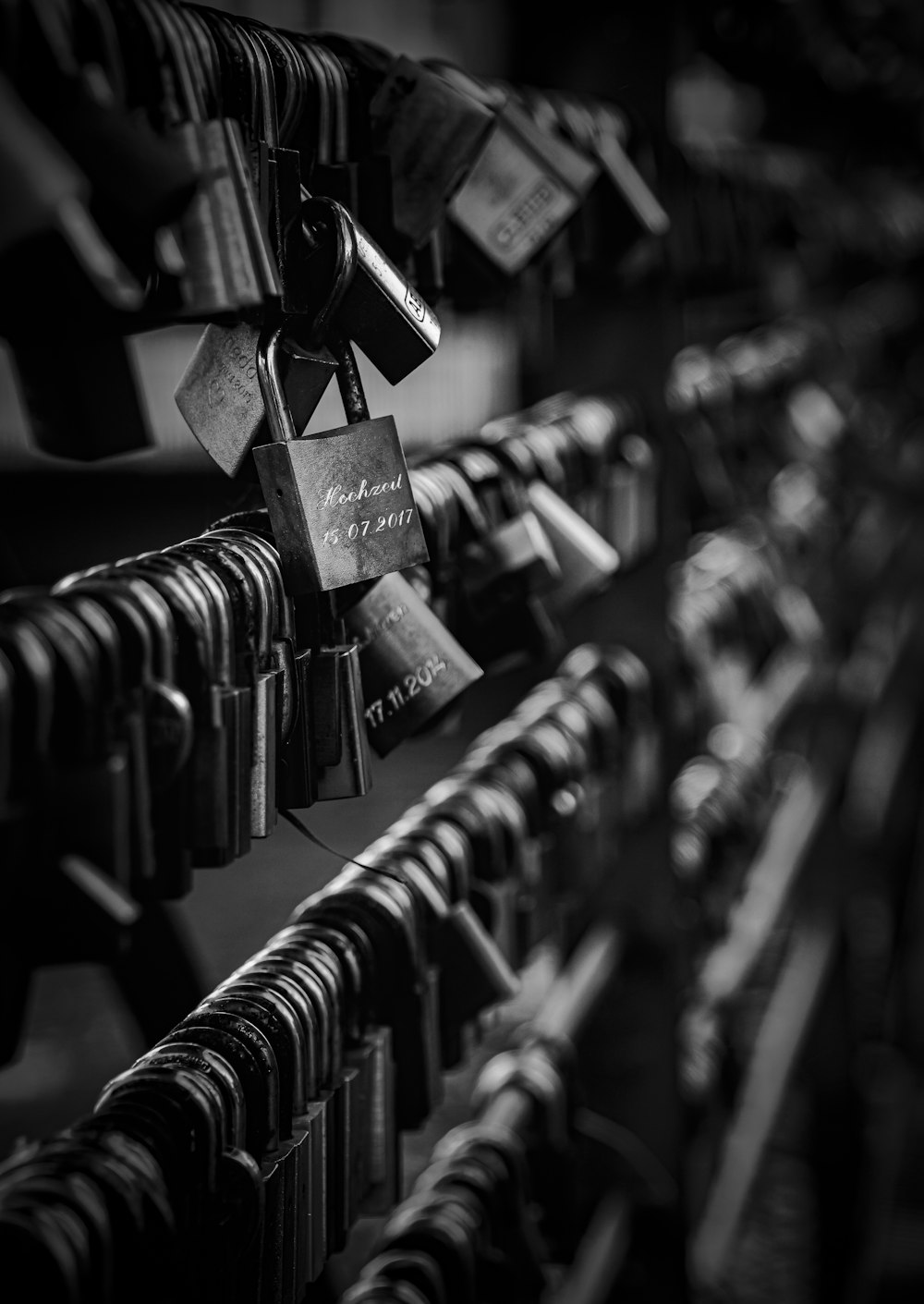 grayscale photography of padlock on wire fence