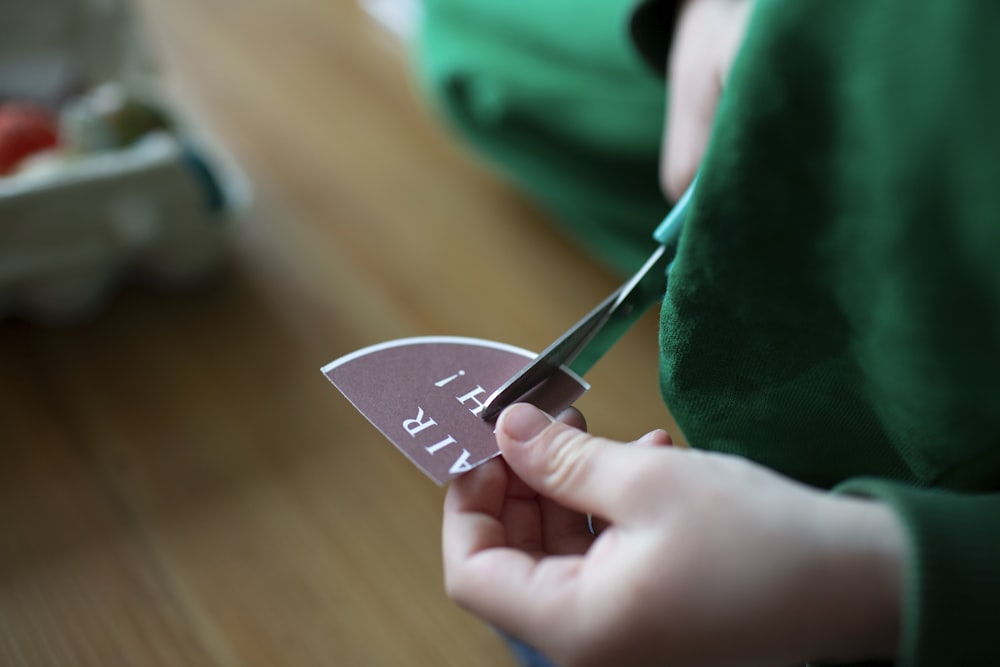 person holding gray and black heart ornament