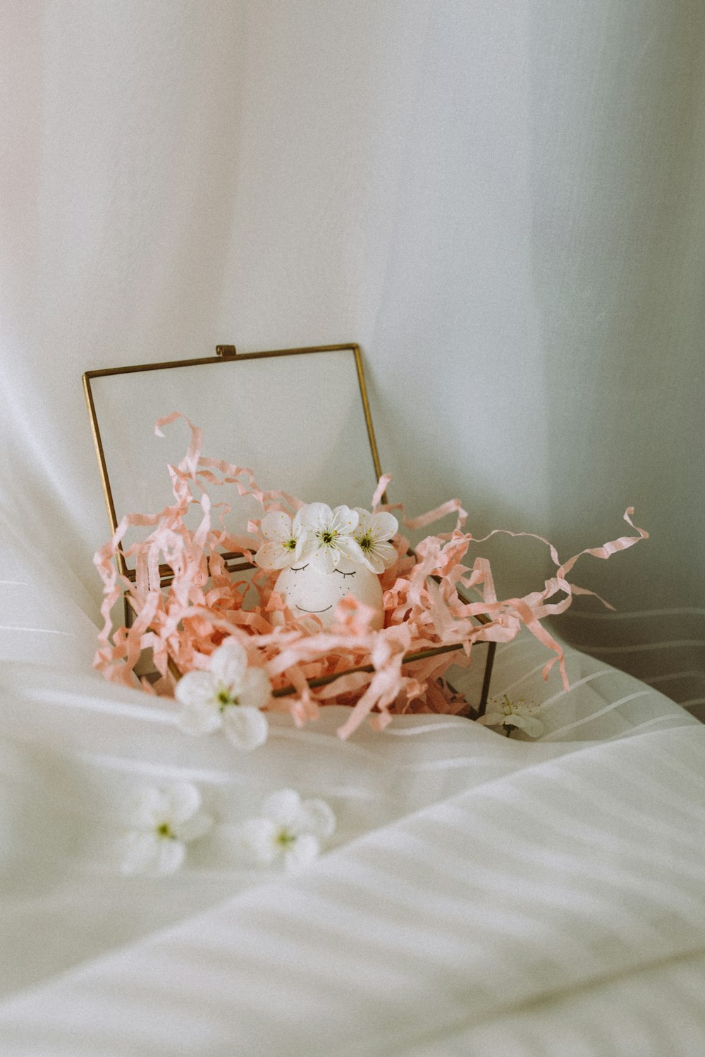 white and pink flower petals on white textile