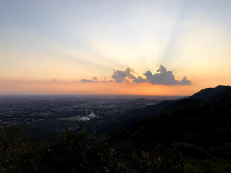 A serene view of Hilton Jabal Omar Suites at sunset with the city lights beginning to glow.