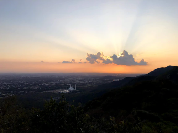 Sunset view over a city skyline with Urdu signage glowing.