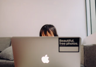 A smiling child using a laptop for an online class in a cozy home setting.