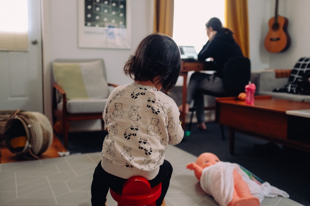 menina na camisa branca e preta que segura o bebê no onesie branco