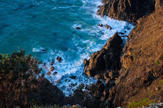 brown rocky mountain beside blue sea during daytime in Sunshine Coast QLD Australia