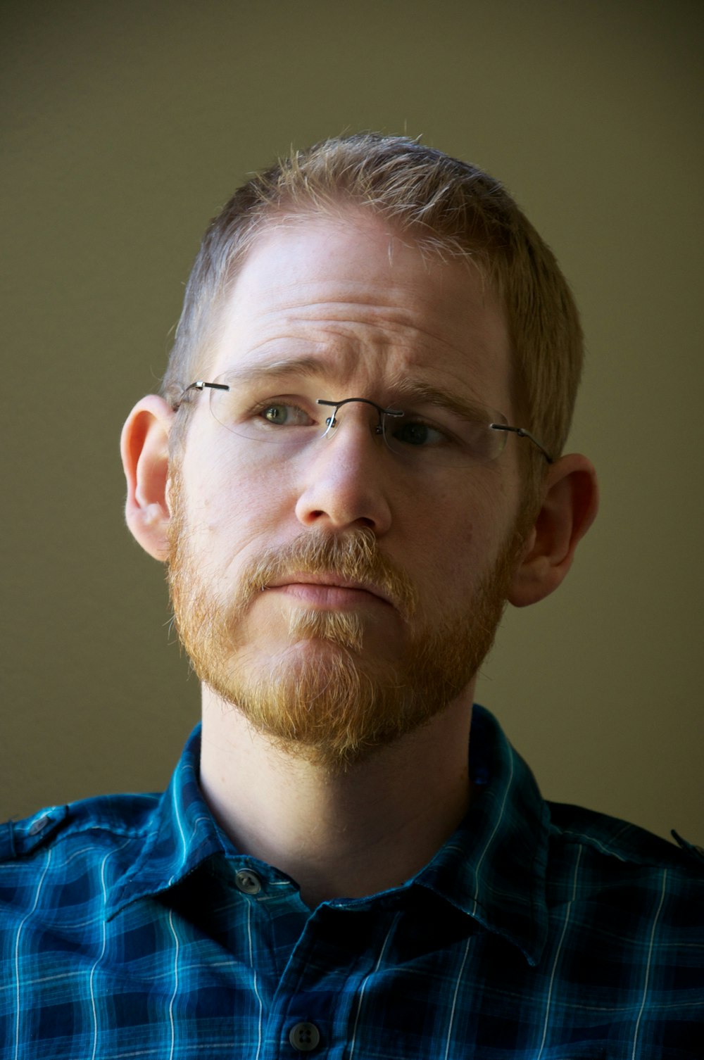 man in blue collared shirt wearing eyeglasses