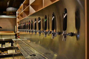 Inside view of a clean, organized long draw beer system installation with glossy pipes.