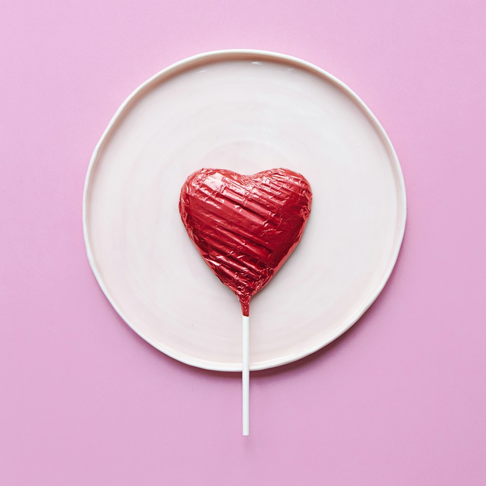 red lollipop on white ceramic round plate