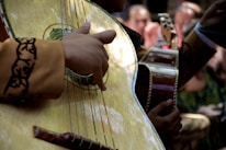 Close-up of musicians playing acoustic guitars with heartfelt expressions.